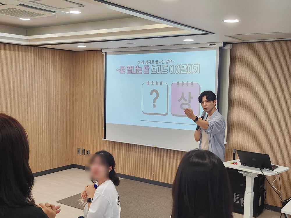 스크린에 퀴즈를 띄우고 참가자들과 문제를 푸는 진행자